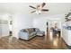 Spacious living room featuring wood floors, a ceiling fan, and easy access to the dining area at 457 Cokesbury Park Ln, Fuquay Varina, NC 27526