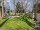 This grassy backyard features mature trees, a patio, and a wooded fence at 4745 Grand Cypress Ct, Raleigh, NC 27604