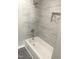 Bathroom features a white tub, tiled walls, and coordinated fixtures creating a clean and inviting space at 523 E Nelson Ave, Wake Forest, NC 27587