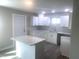 Bright kitchen features white cabinets, modern countertops, an island and stainless steel sink at 523 E Nelson Ave, Wake Forest, NC 27587