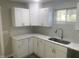 The modern kitchen includes stainless steel appliances, marble countertops and white cabinets at 523 E Nelson Ave, Wake Forest, NC 27587