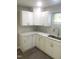 Modern kitchen features white cabinets, stainless steel sink, and mosaic tile backsplash at 523 E Nelson Ave, Wake Forest, NC 27587
