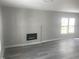 Living room featuring hardwood floors, a fireplace, and large windows, offering a blend of comfort and style at 523 E Nelson Ave, Wake Forest, NC 27587