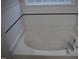 Bathroom with a white tub and tile surround at 5402 Whisperwood Dr, Durham, NC 27713