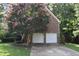 Charming brick home with a two-car garage and a beautiful pink-blossomed tree in the front yard at 5402 Whisperwood Dr, Durham, NC 27713