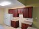Kitchen featuring wood cabinets, white appliances and a tile backsplash at 5402 Whisperwood Dr, Durham, NC 27713