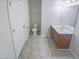 Bright bathroom featuring a single sink vanity and a toilet with tiled floor at 543 Camel St, Clayton, NC 27520