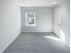 Bright bedroom with soft carpet, a large window, and a door at 543 Camel St, Clayton, NC 27520