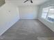 Spacious living room featuring neutral carpet and paint, a ceiling fan, and a large window at 543 Camel St, Clayton, NC 27520