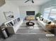 Bright, staged living room with modern furnishings, ceiling fan, large windows and a neutral color palette at 543 Camel St, Clayton, NC 27520