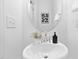Clean powder room featuring a stylish sink, round mirror, and neutral decor for a modern look at 55 Mable Court # 5, Lillington, NC 27546