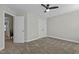 Bright bedroom features neutral walls, plush carpet, ceiling fan, and closet space at 5601 Garnet Meadow Rd, Knightdale, NC 27545
