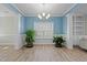 Light-filled dining room features wood floors, stylish chandelier and light blue accent wall at 5601 Garnet Meadow Rd, Knightdale, NC 27545