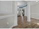 Open-concept living space featuring hardwood floors, elegant columns, and a glimpse of the staircase at 5601 Garnet Meadow Rd, Knightdale, NC 27545