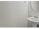 Clean powder room featuring pedestal sink and round mirror at 5601 Garnet Meadow Rd, Knightdale, NC 27545