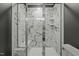 Modern bathroom shower with a glass door and elegant marble-patterned tile throughout at 5601 Garnet Meadow Rd, Knightdale, NC 27545