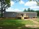 Well-maintained backyard featuring a wooden deck and a view of the home's exterior at 5780 Plain View Hwy, Dunn, NC 28334