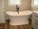 A luxurious white soaking tub with sleek, modern fixtures in a brightly lit bathroom at 5780 Plain View Hwy, Dunn, NC 28334