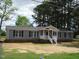 Charming single-story home with gray siding, black shutters, and a welcoming front porch with white railings at 5780 Plain View Hwy, Dunn, NC 28334