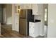 Bright kitchen with stainless steel refrigerator, white cabinets, and hardwood flooring at 5780 Plain View Hwy, Dunn, NC 28334