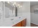 Bright bathroom featuring double sinks, a large mirror, and wainscoting at 613 Holly Thorn Trce, Holly Springs, NC 27540