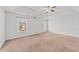 Spacious bedroom featuring neutral carpeting, two windows and a ceiling fan at 613 Holly Thorn Trce, Holly Springs, NC 27540