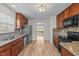 Well-lit kitchen with wood cabinets, granite countertops, stainless steel appliances, and mosaic tile backsplash at 613 Holly Thorn Trce, Holly Springs, NC 27540