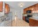 Modern kitchen with wood cabinets, granite countertops, and stainless steel appliances at 613 Holly Thorn Trce, Holly Springs, NC 27540