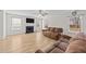 Living room boasts a fireplace, wood floors, a ceiling fan, and two windows covered with blinds at 613 Holly Thorn Trce, Holly Springs, NC 27540