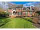 Charming brick two-story home with a manicured lawn, black shutters, dormer windows, and a welcoming front porch at 6320 Bayswater Trl, Raleigh, NC 27612