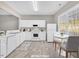 Bright kitchen with white appliances, ample counter space, and a cozy dining area at 706 Canyon Lake Cir, Morrisville, NC 27560