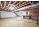 Unfinished basement with support beams, and brick walls. Featuring a pool table and stairs to upstairs at 7414 Virgilina Rd, Roxboro, NC 27574