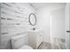 Charming bathroom showcasing a decorative wood wall, round mirror, toilet, and a white vanity at 7414 Virgilina Rd, Roxboro, NC 27574