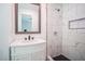 Well-lit bathroom featuring a tiled walk-in shower with niche, and a vanity with modern fixtures at 7414 Virgilina Rd, Roxboro, NC 27574