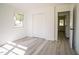 Bedroom showcasing a double-door closet, light gray floors, white walls, and natural lighting at 7414 Virgilina Rd, Roxboro, NC 27574