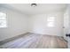 Spacious bedroom features new light gray floors, windows, and a doorway to the rest of the house at 7414 Virgilina Rd, Roxboro, NC 27574