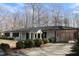 Single-story home boasting charming curb appeal with lush landscaping and a convenient carport at 7414 Virgilina Rd, Roxboro, NC 27574