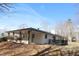Rear exterior featuring a covered patio and an attached deck against a treed backdrop at 7414 Virgilina Rd, Roxboro, NC 27574