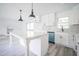 Open kitchen with white cabinets, a large island, and updated appliances at 7414 Virgilina Rd, Roxboro, NC 27574