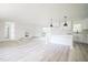 Open concept living space featuring new light gray floors, fireplace, and kitchen with white cabinets at 7414 Virgilina Rd, Roxboro, NC 27574
