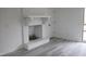 Living room features a white-painted brick fireplace and light-colored hardwood flooring at 7414 Virgilina Rd, Roxboro, NC 27574