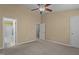 Spacious bedroom with carpet, fan, and connecting bathroom and closet at 7850 Silverthread Ln, Raleigh, NC 27617