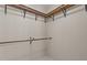 Walk-in closet featuring wood shelves with metal supports and beige walls at 7850 Silverthread Ln, Raleigh, NC 27617