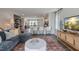 Open-concept living room with a large sofa, stylish rug, and view of the modern kitchen at 813 Washington St, Fuquay Varina, NC 27526