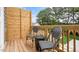 Private outdoor space with chairs, a small table, and a wooden privacy fence surrounded by lush greenery at 813 Washington St, Fuquay Varina, NC 27526