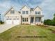 Inviting two-story home featuring a three-car garage and beautifully landscaped front yard at 825 Willow Tower Ct, Rolesville, NC 27571