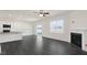 Open-concept living area featuring a fireplace, modern kitchen, and backyard access at 94 Paper Birch Way, Fuquay Varina, NC 27526