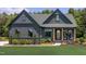 Charming modern farmhouse with a dark exterior, well-manicured lawn, and inviting front porch at 0 High Rock Rd, Efland, NC 27243