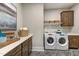 Functional laundry room with modern washer and dryer, ample counter space, and cabinet storage for efficient organization at 0 High Rock Rd, Efland, NC 27243