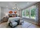 Spacious bedroom featuring a king bed, stylish decor, large windows, and a cozy seating area with two chairs at 0 High Rock Rd, Efland, NC 27243